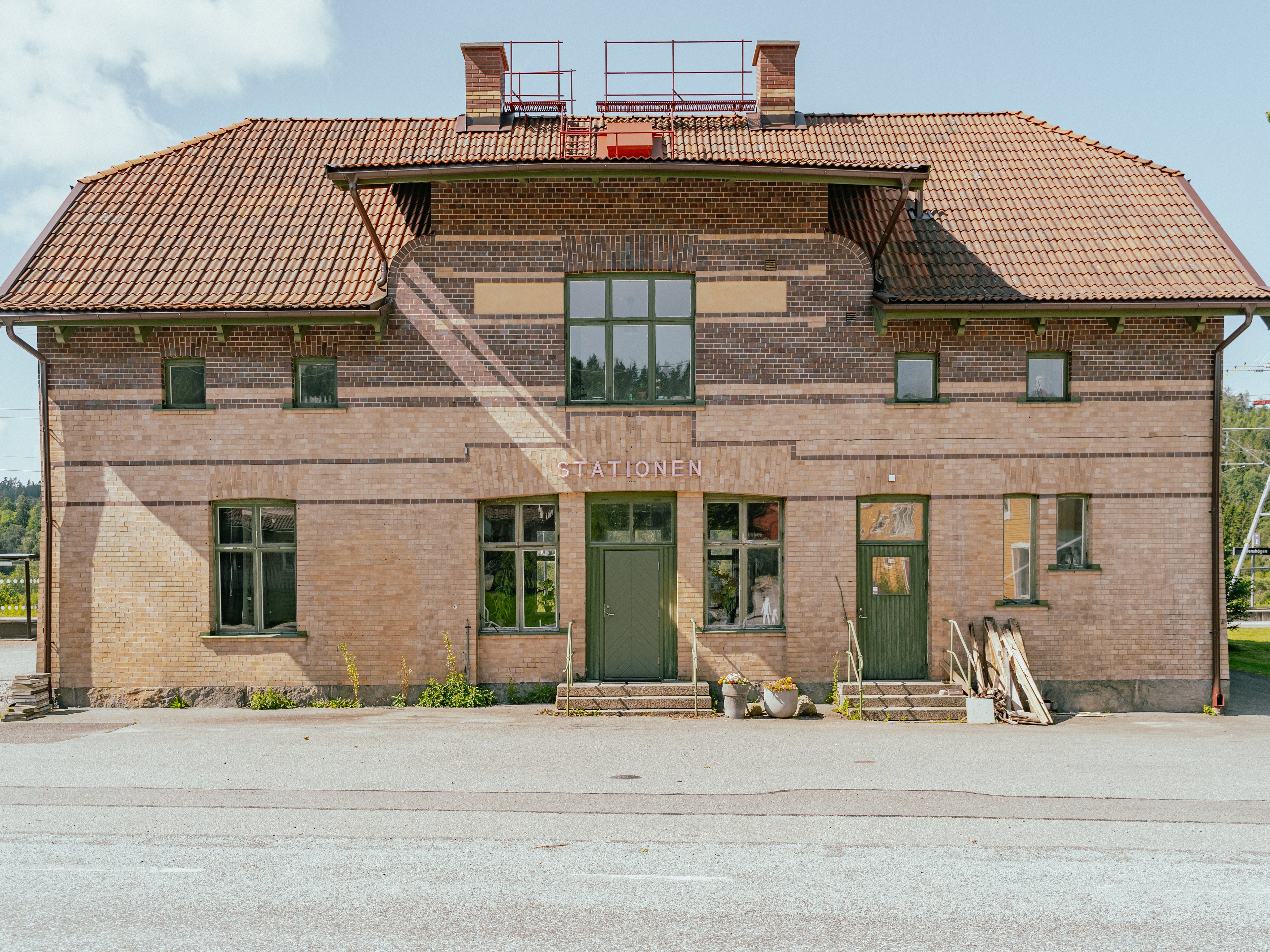 Ett gammalt hus i tegel med en skylt där det står stationen