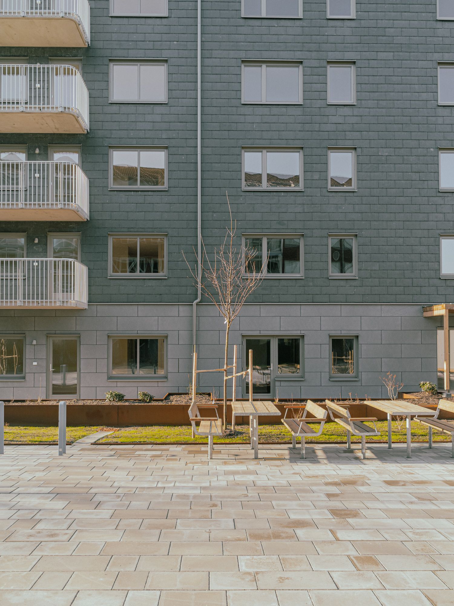 En husfasad med bänkar och bord framför