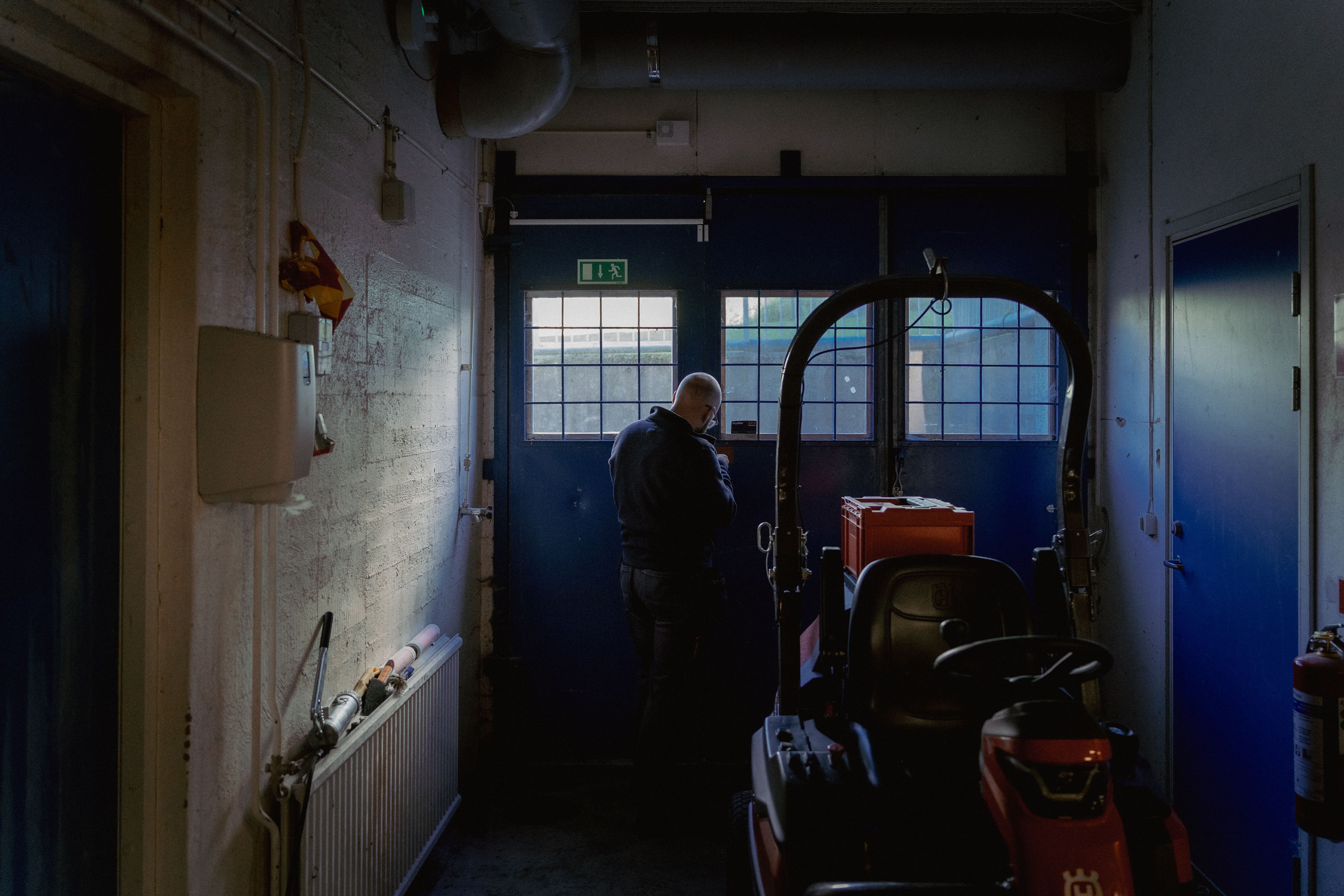 En man låser upp en port i en källare