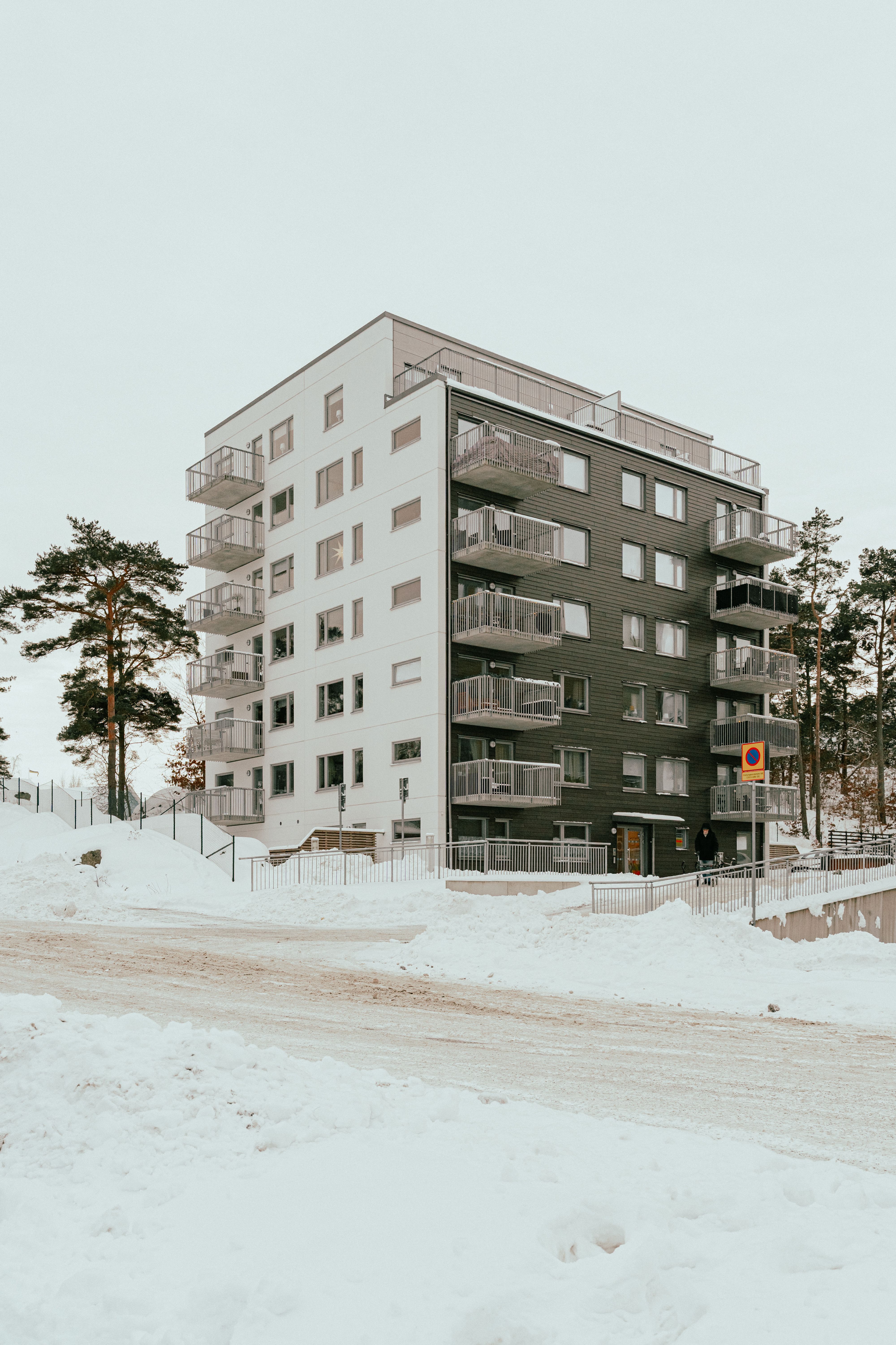 Ett sexvåningshus och väger med mycket snö