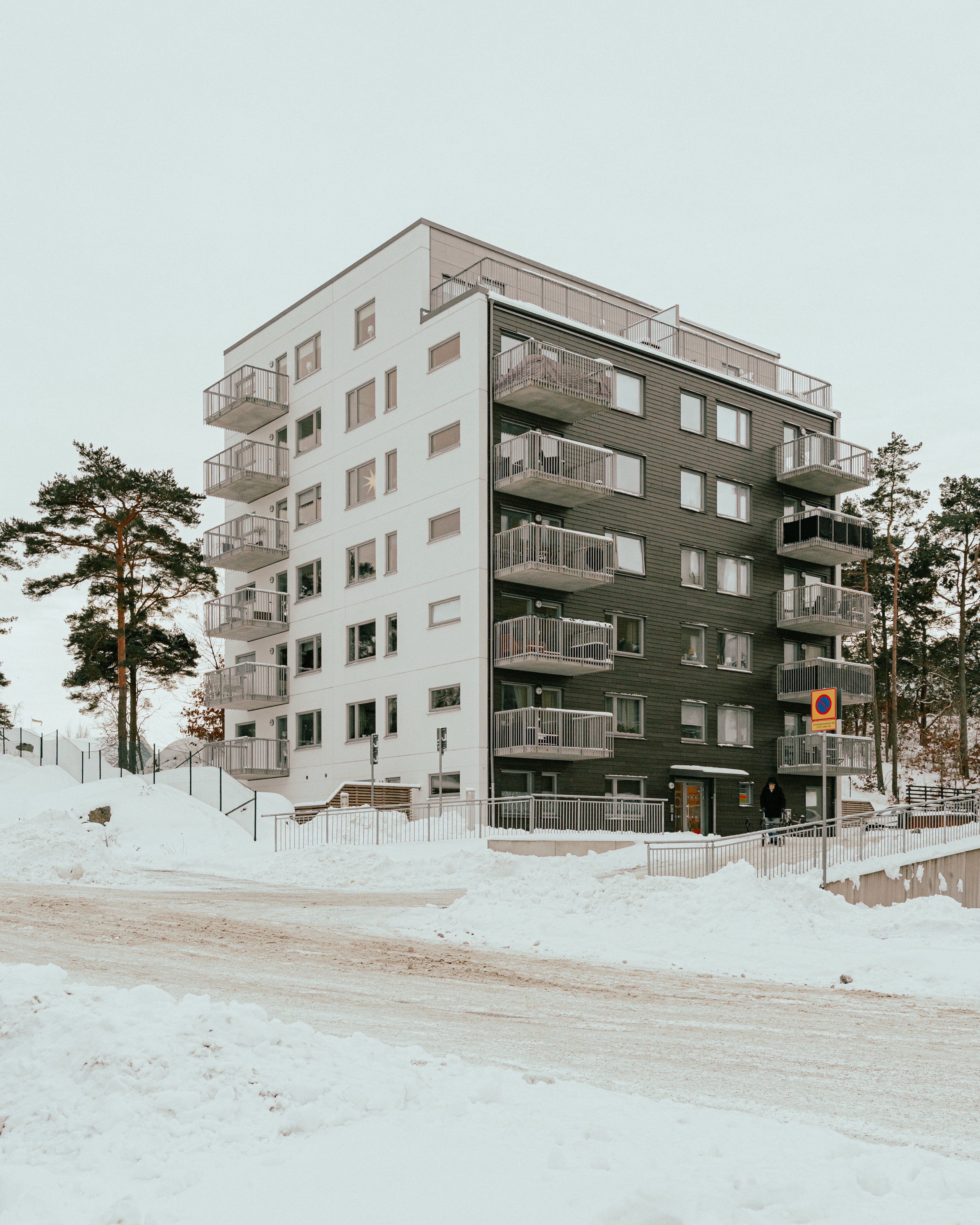 Ett sexvåningshus och väger med mycket snö