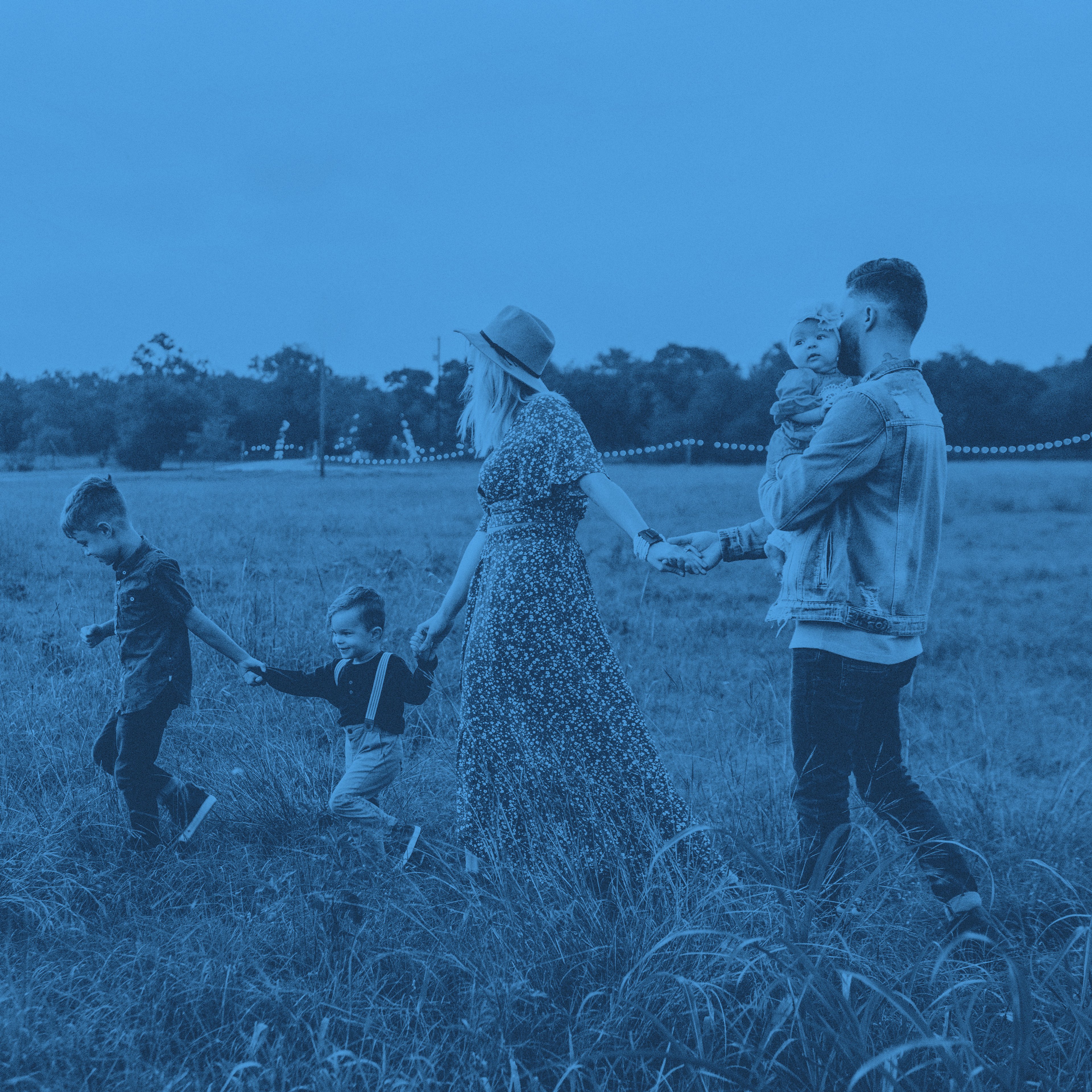 En familj på fem personer vandrar över en äng