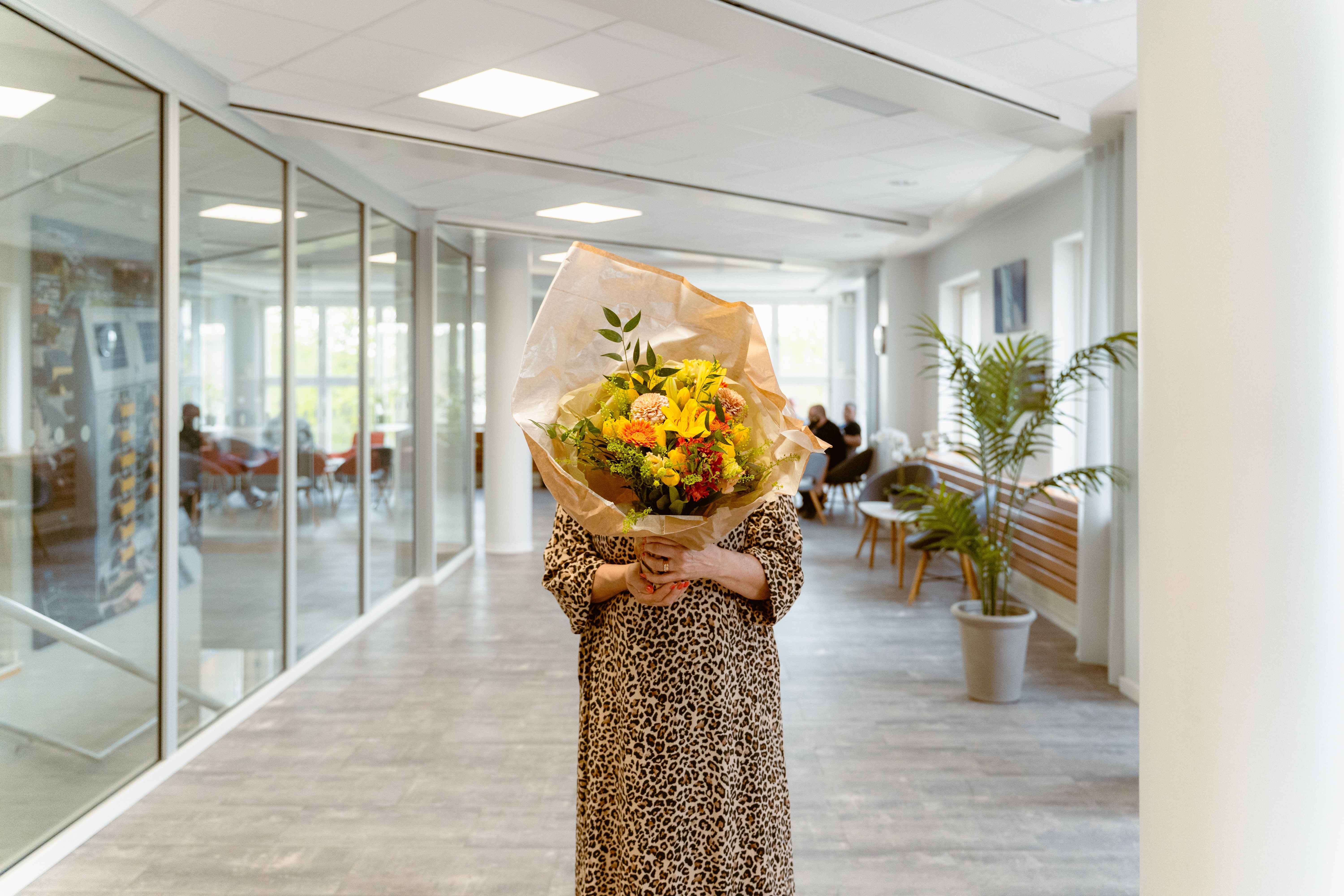 En person håller en stor bukett blommor framför sig