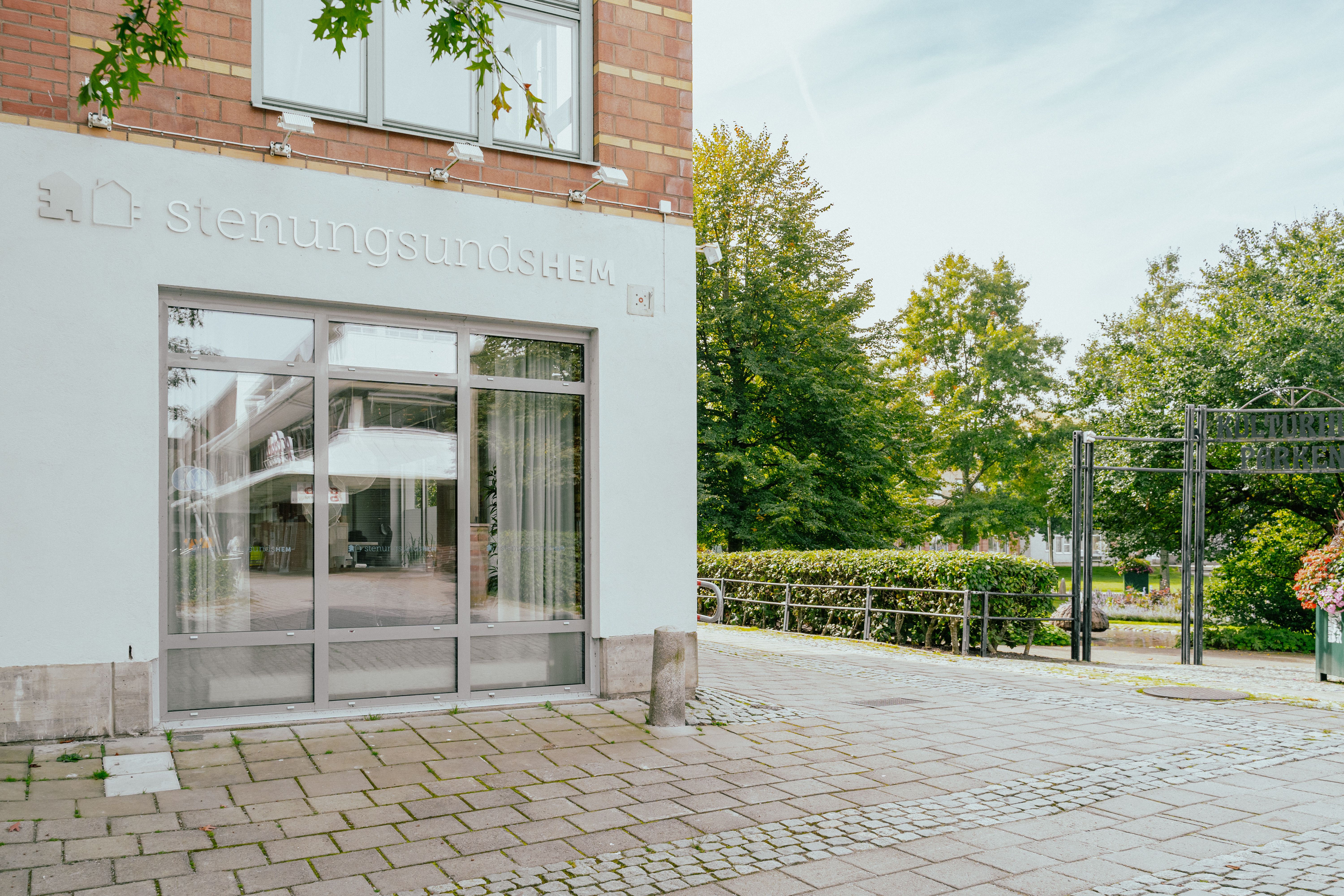 Ett skyltfönster och en skylt med Stenungsundshems logotyp