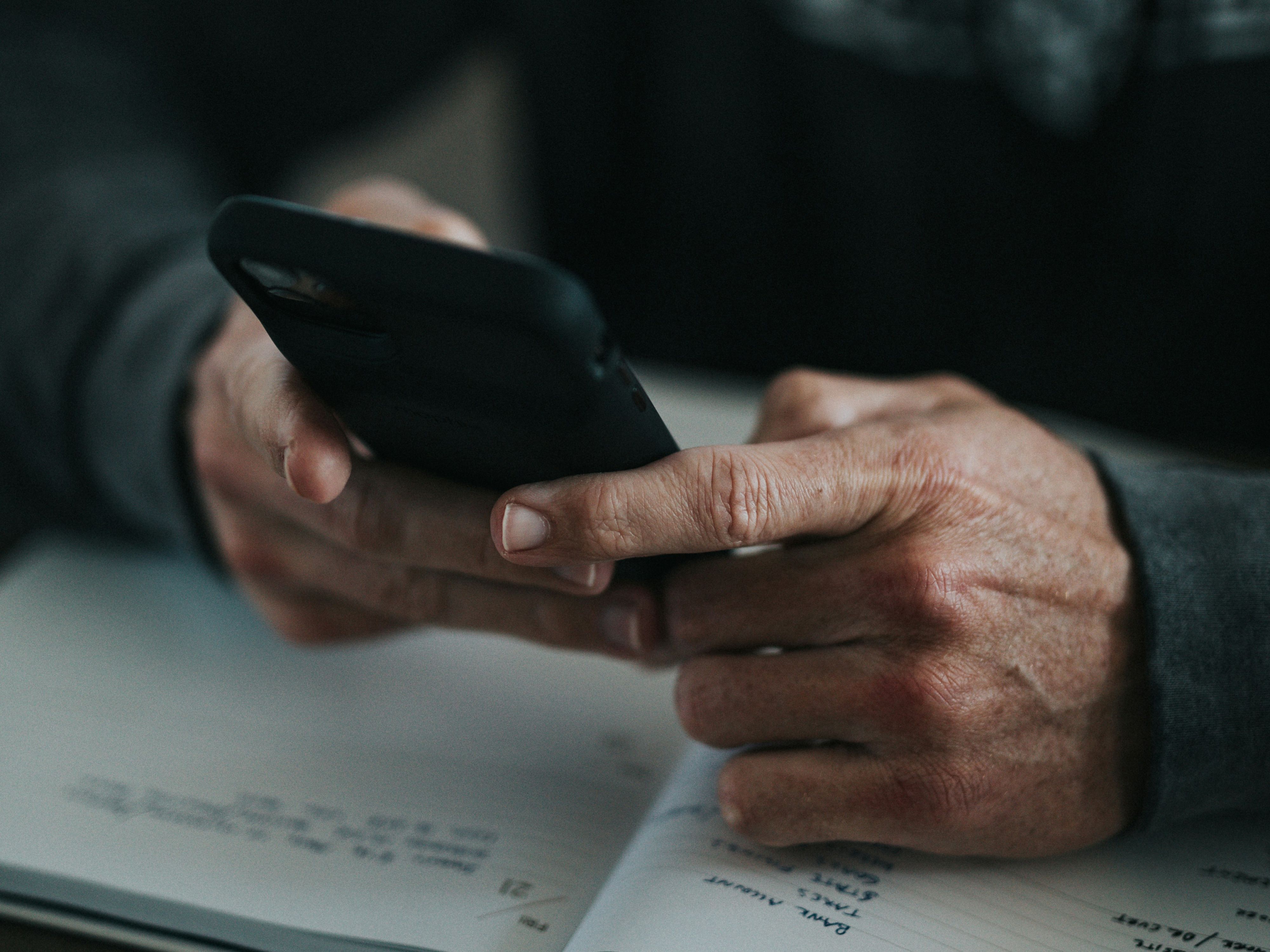 Två händer håller i en mobiltelefon