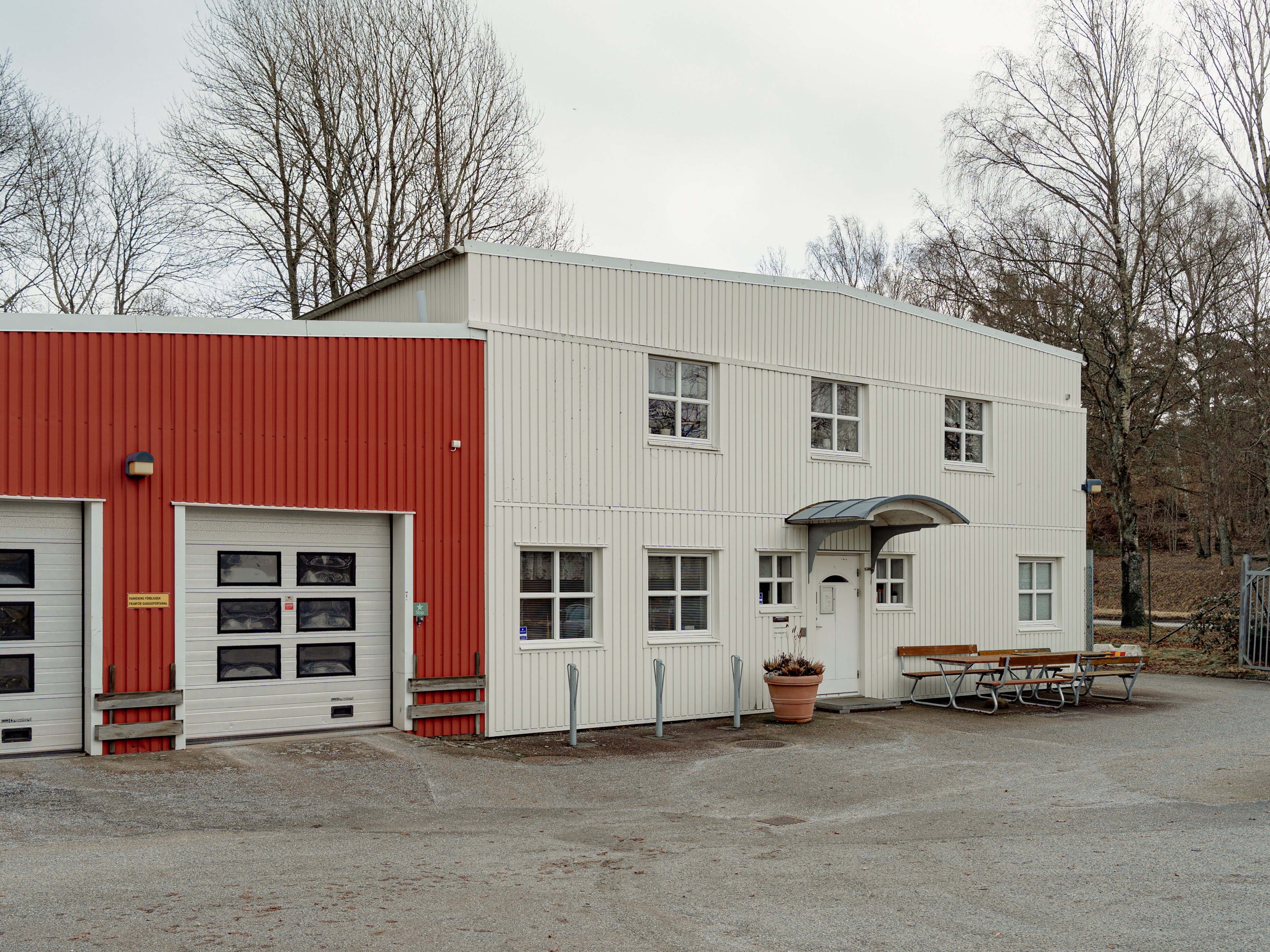 Tvåvåningsbyggnad med bänkar framför