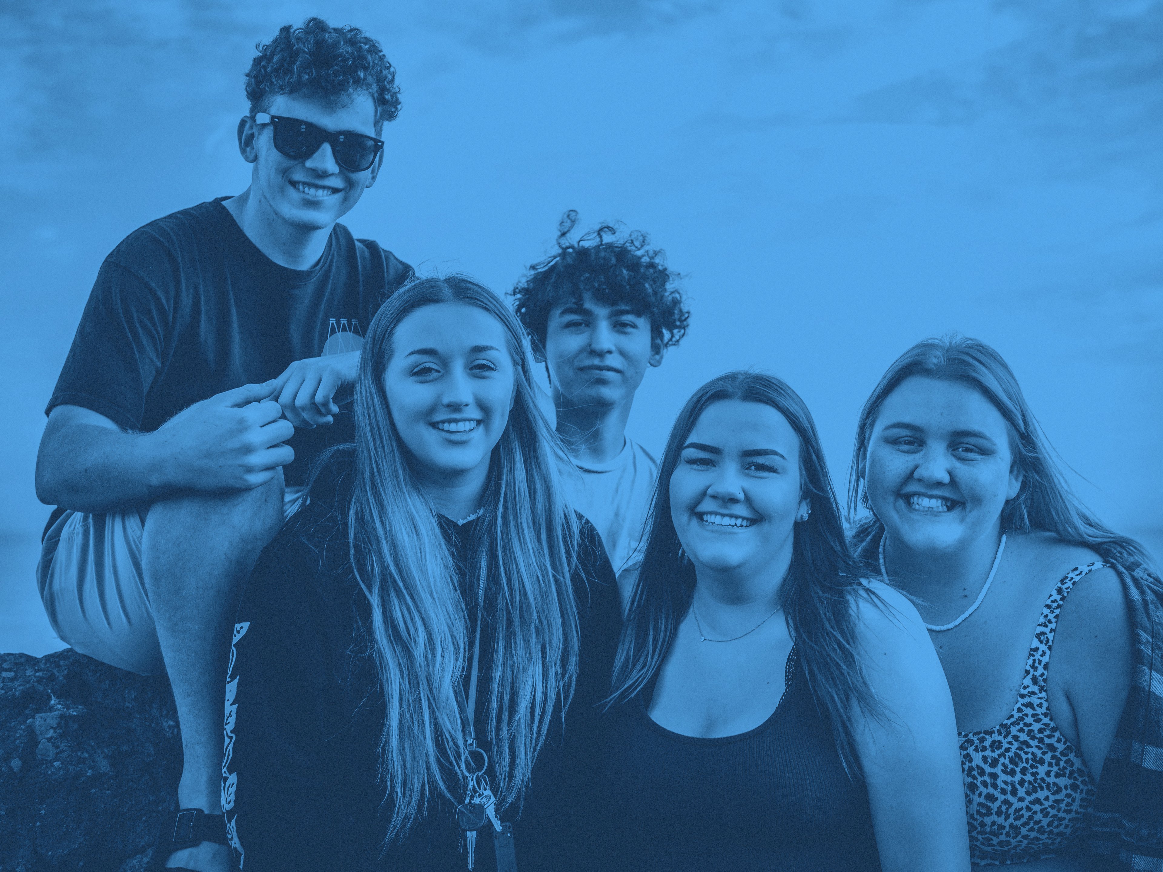 Fem ungdomar tittar in i kameran