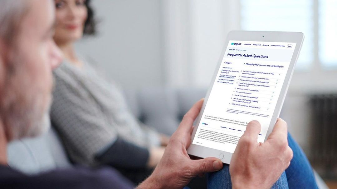 Adult male with grey hair sitting indoors, looking at tablet
