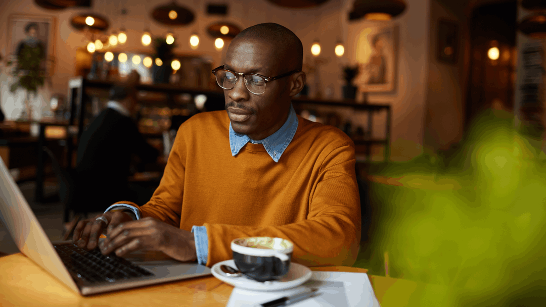 Man sat on his laptop while in a coffee shop