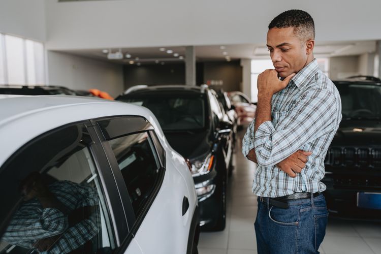 Man looking at a car in car dealership