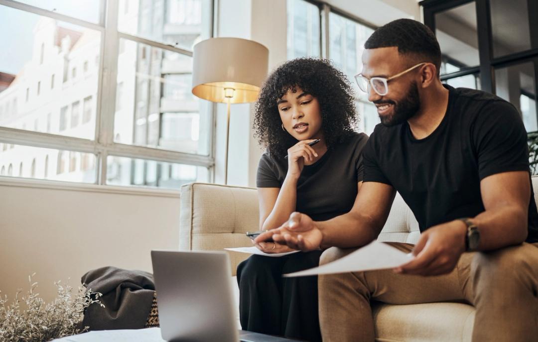 Couple sitting in front of a laptop discussing finances