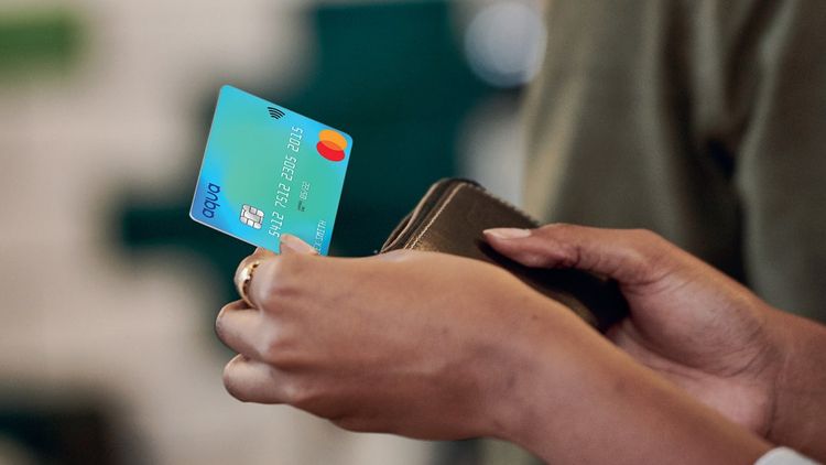 Close-up of adult female holding credit card for shopping and banking.