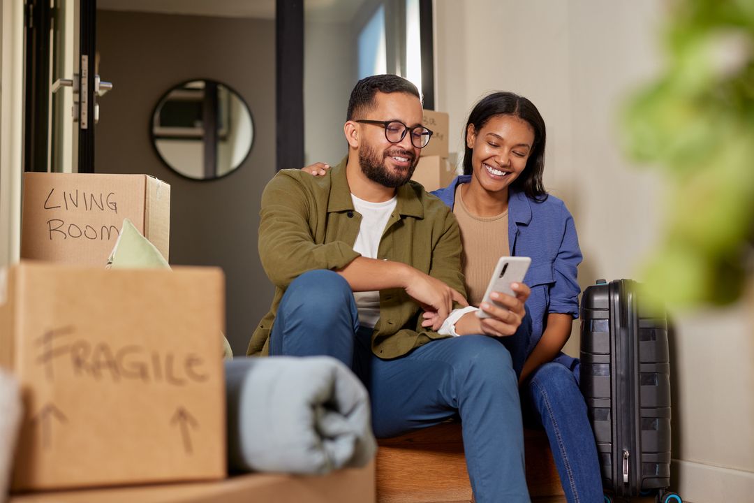 Couple sat on the floor surrounded by packing boxes