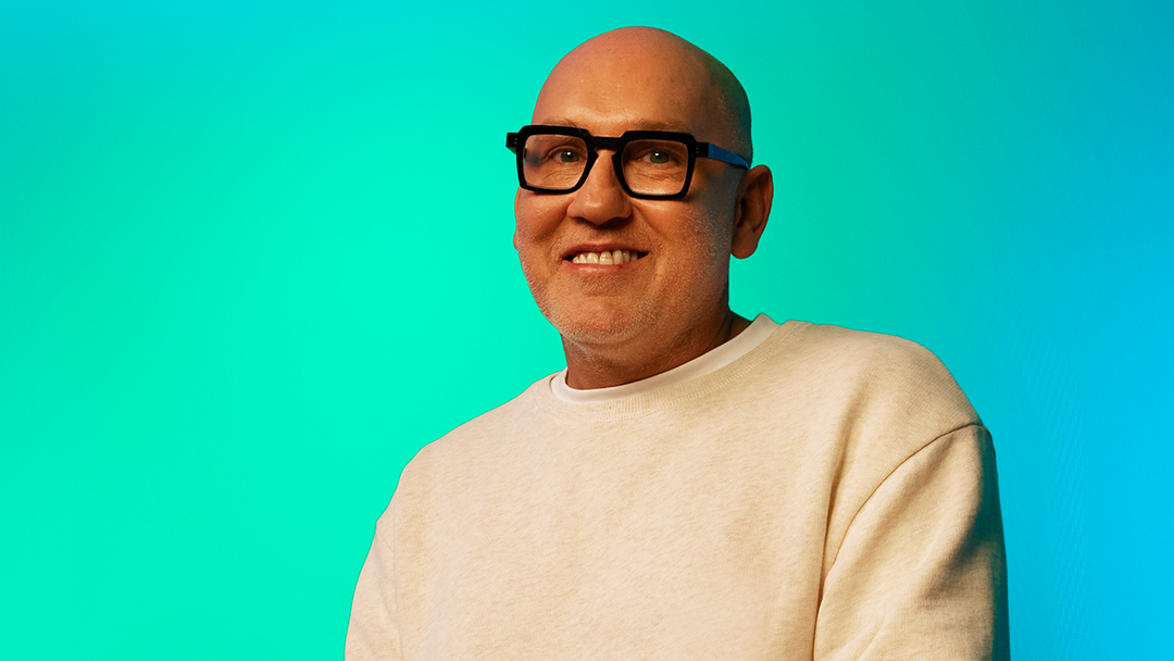 Man smiling against green background