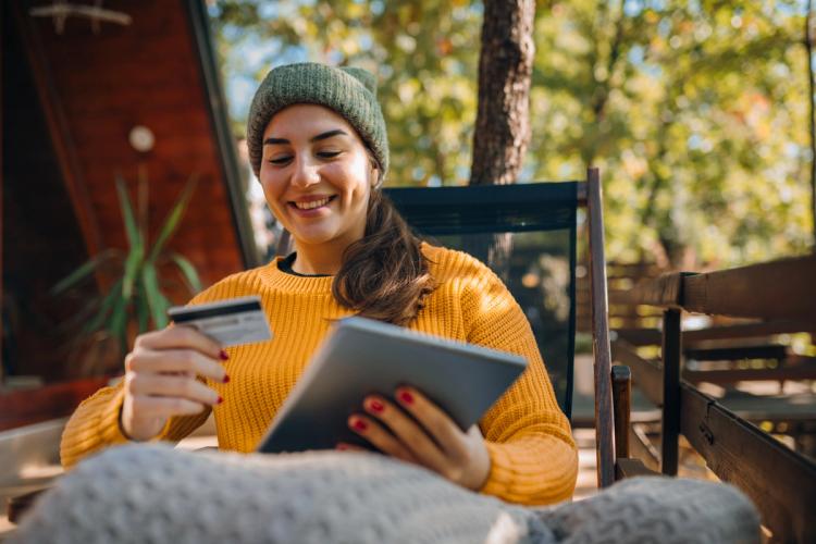 Woman sitting outside looking at her credit card
