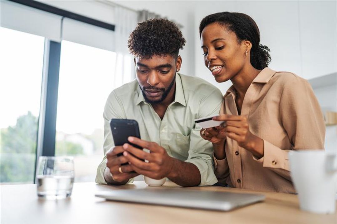Couple looking at their phone and credit card