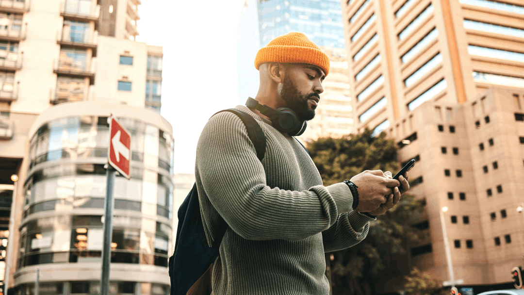 Man exploring a city, looking at his phone