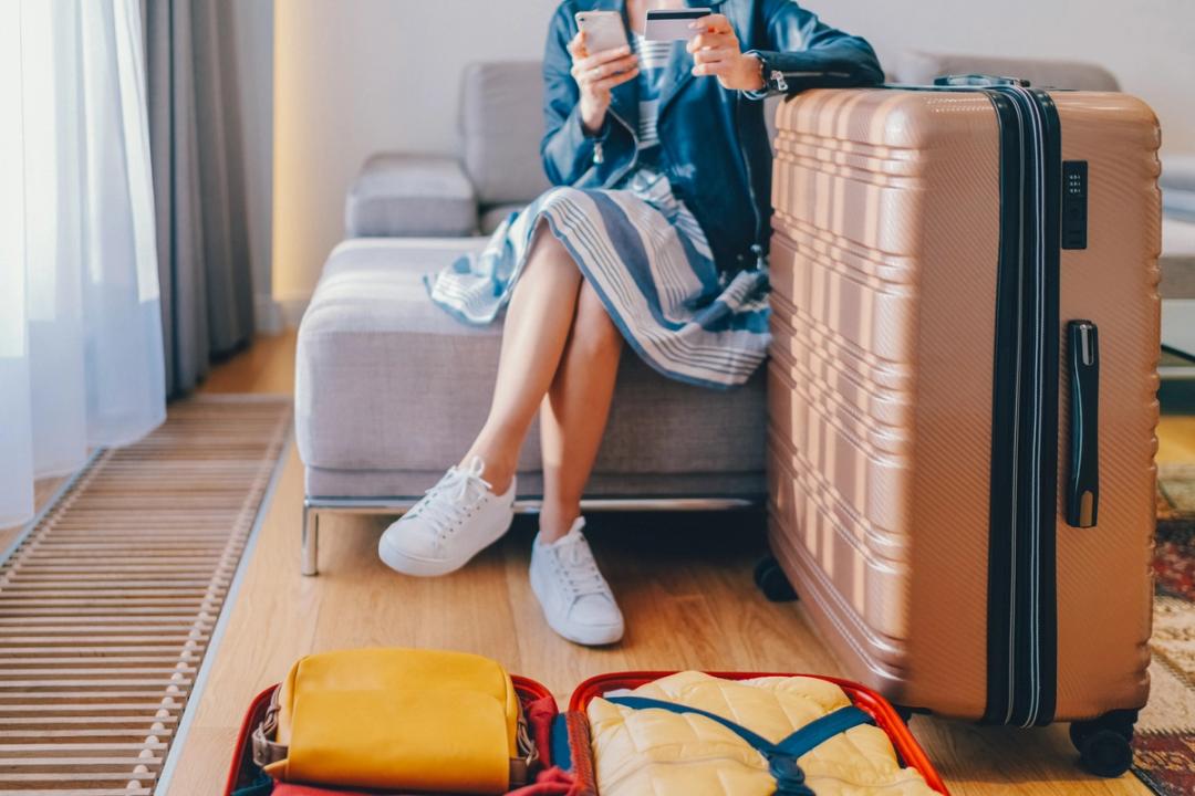 Woman sat with her packed suitcases