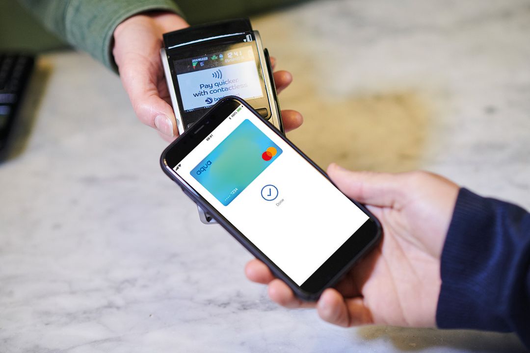 A phone with aqua card on the screen making a contactless payment