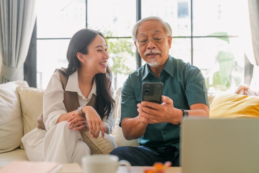 Man and woman looking at their phone smiling