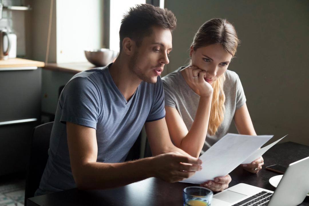 Couple sat at a table looking at paperwork