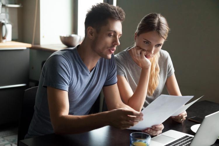 Couple sat at a table looking at paperwork 