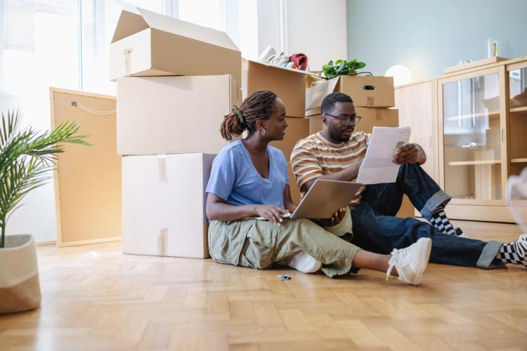 Couple sat on the floor with moving boxes