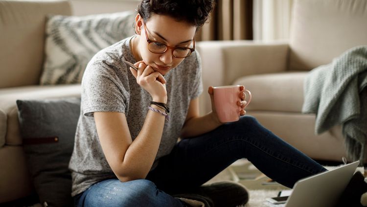 An adult relaxing on a sofa indoors, wearing casual clothing, in a home interior living room