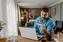 Man checking credit card in front of his laptop