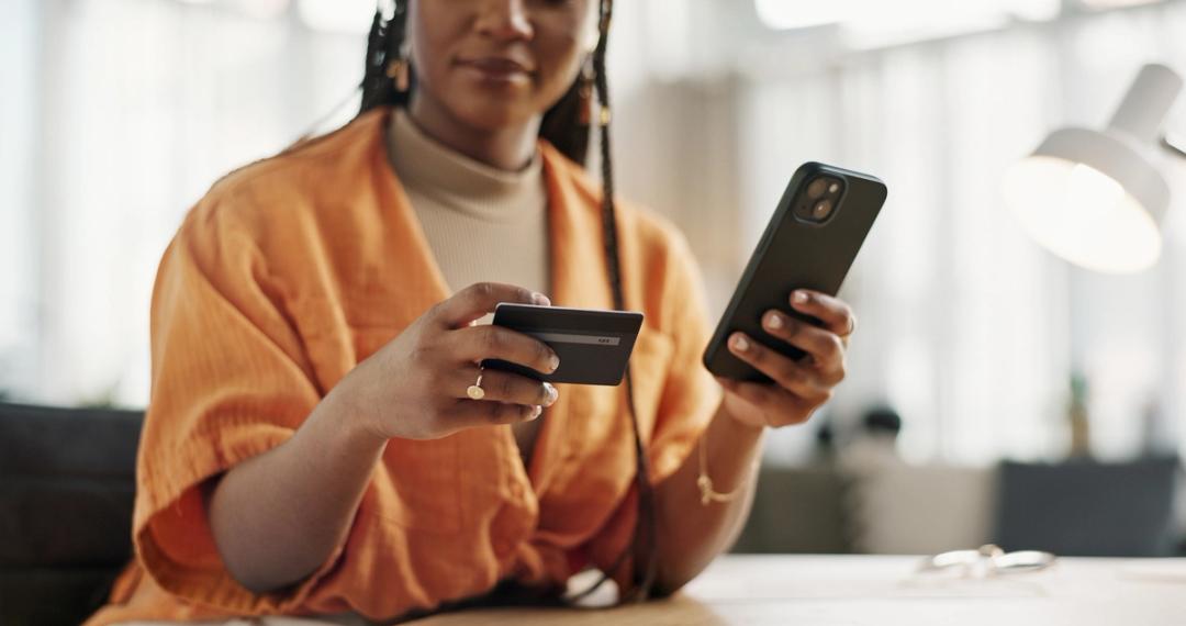 Woman holding her credit card and phone
