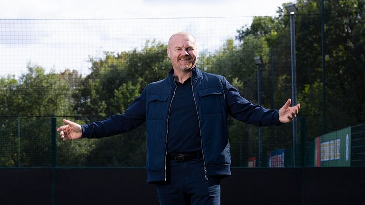 Football coach Sean Dyche standing on a pitch with open arms