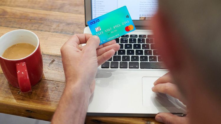 Close-up of a man's hand working with a credit card, banking and shopping online.