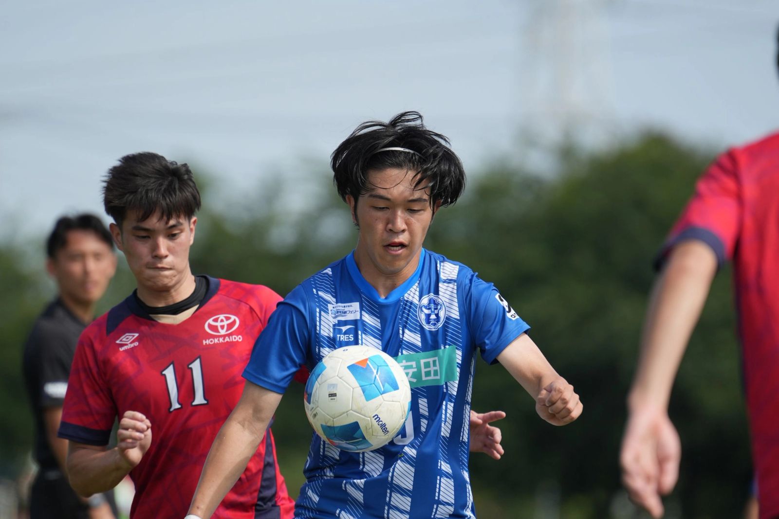 相手選手と競り合いながらボールを追う選手