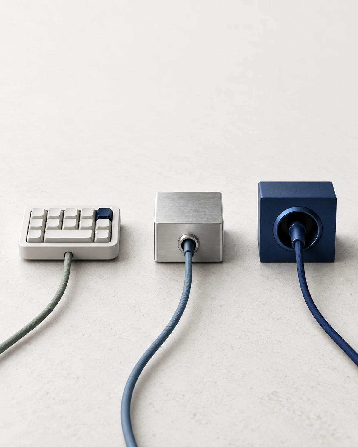 A cream keypad and separate silver and cobalt cable sockets on a pale stone surface.