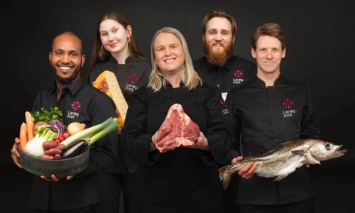 Smilende ansatte hos Lerøy Mat holder frem mat