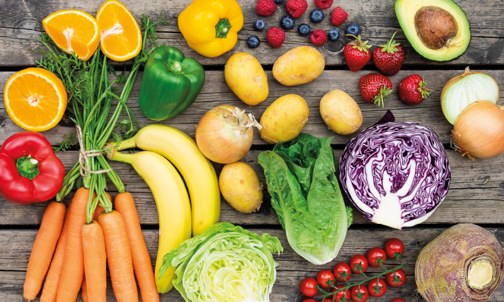 Frukt og grønt ligger spredt på et bord