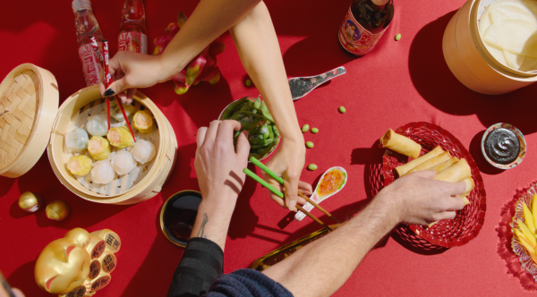 Bord med asiatisk mat som noen spiser fra