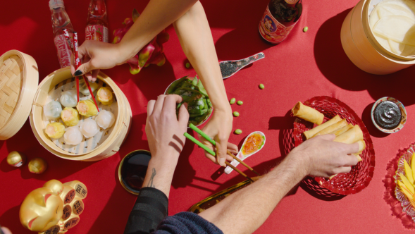 Bord med asiatisk mat som noen spiser fra