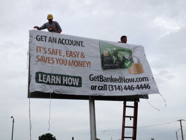 Bank On Save Up billboard being installed above a roadway