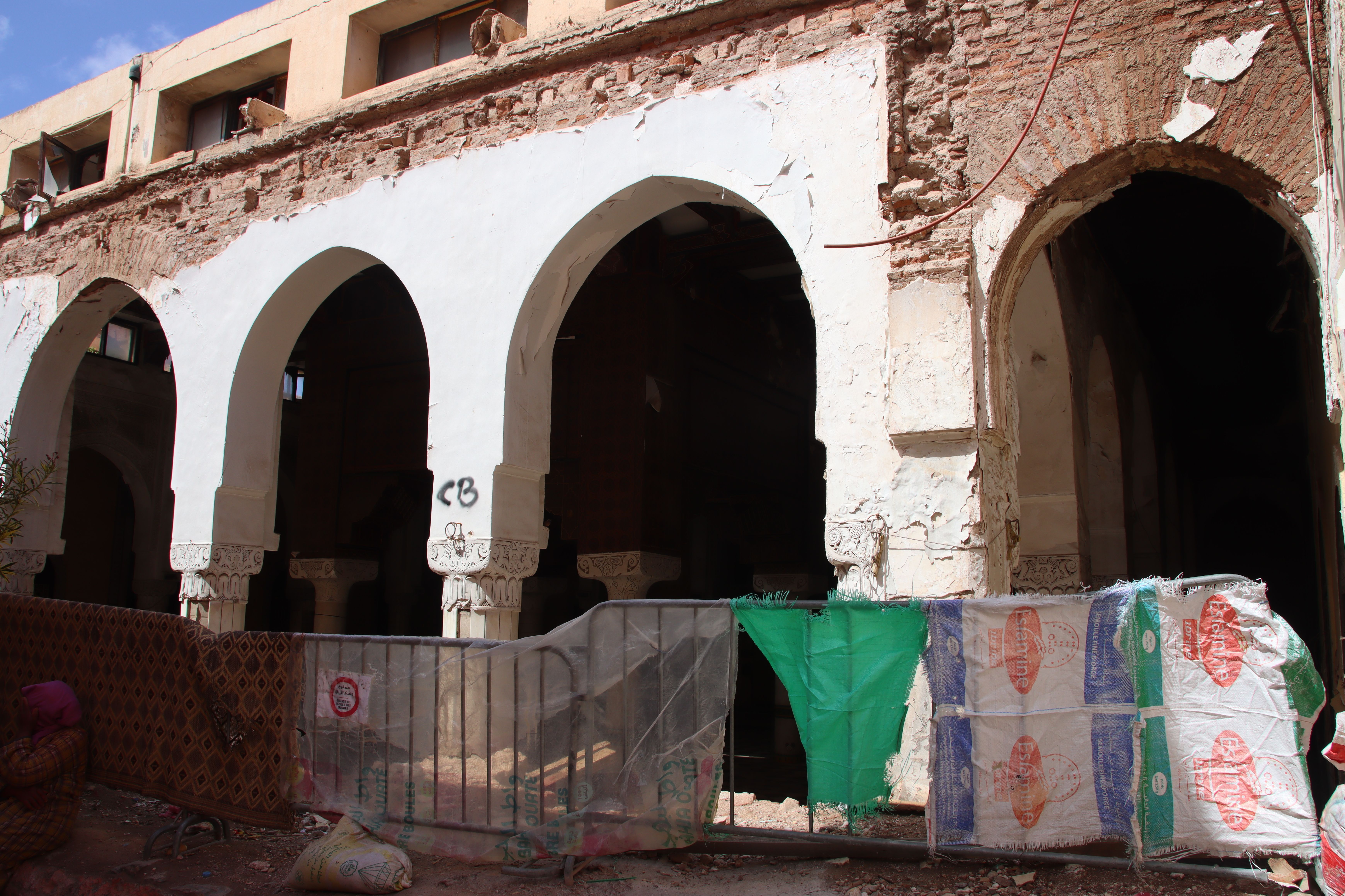 Arcades of a ruined mosque in the Marrakech medina, its walls cracked and propped up