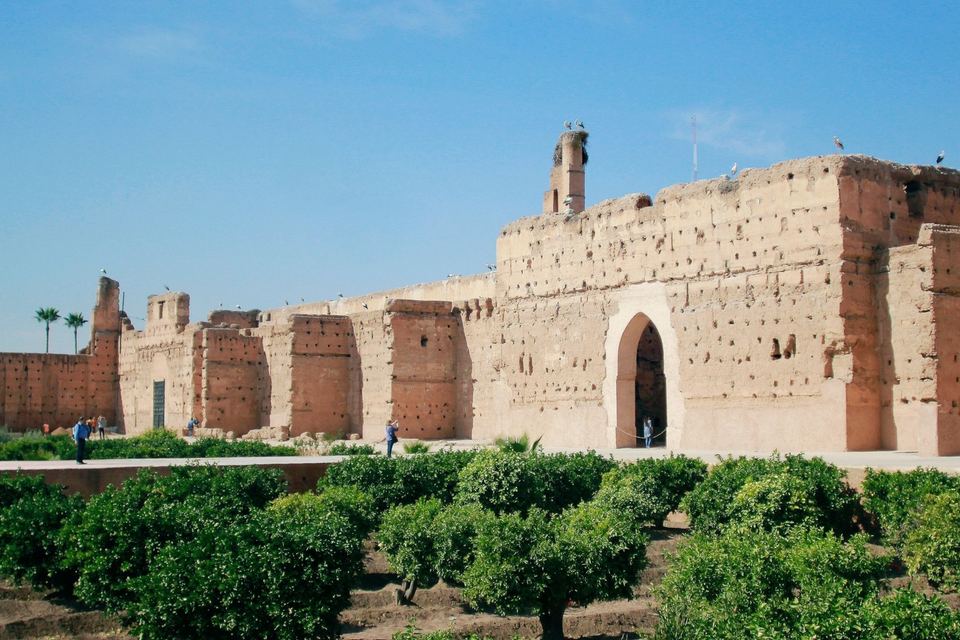 Hauts murs de pisé érodés du palais El Badi, au-dessus de jardins d'orangers