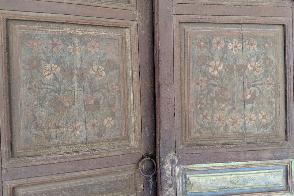 Two wooden door leaves with panels painted with faded flowers, Bahia Palace
