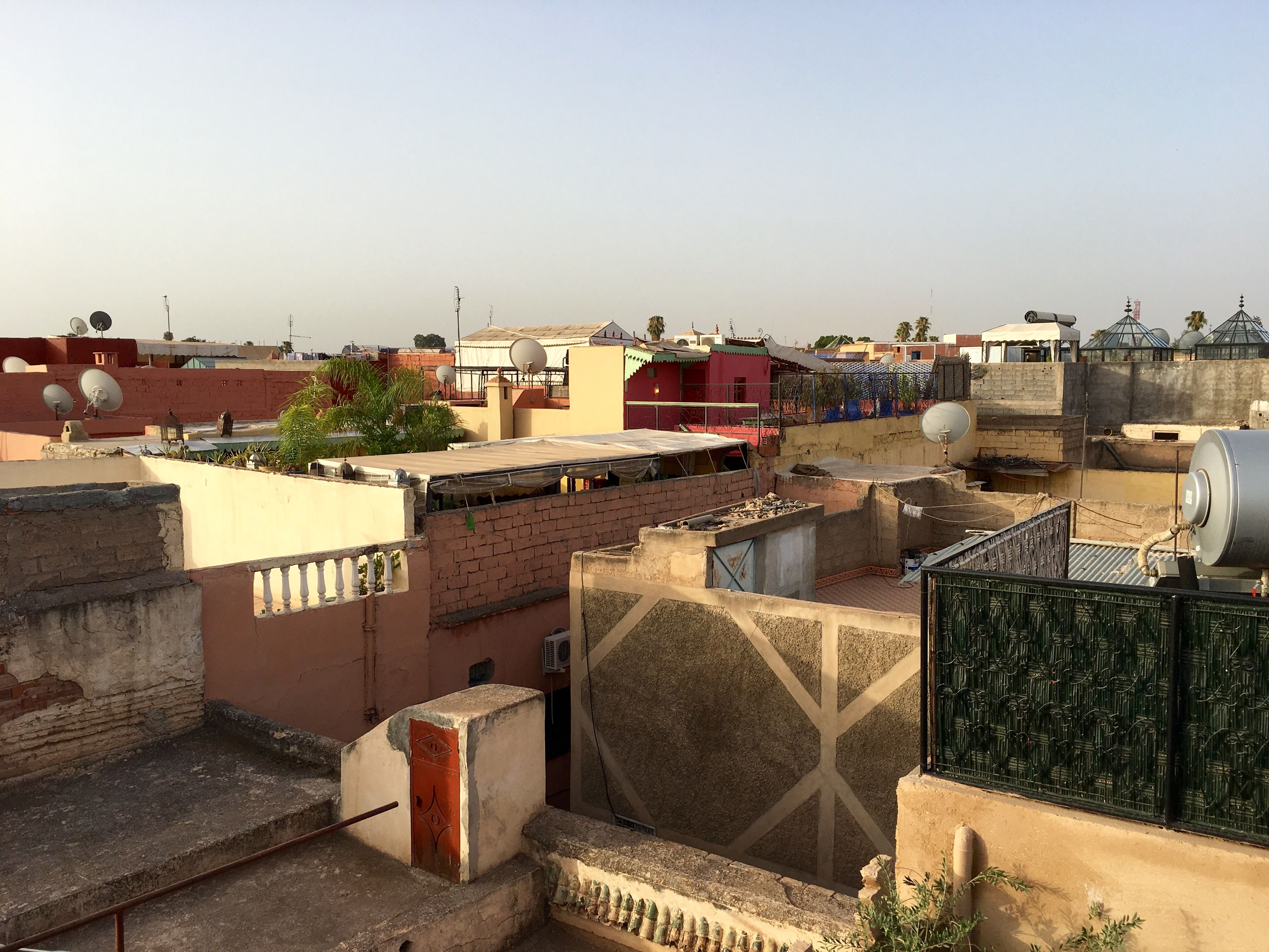 سطوح مراكش في الصباح الباكر، بدرابزينات من الحديد المطروق وجدران بلون المغرة