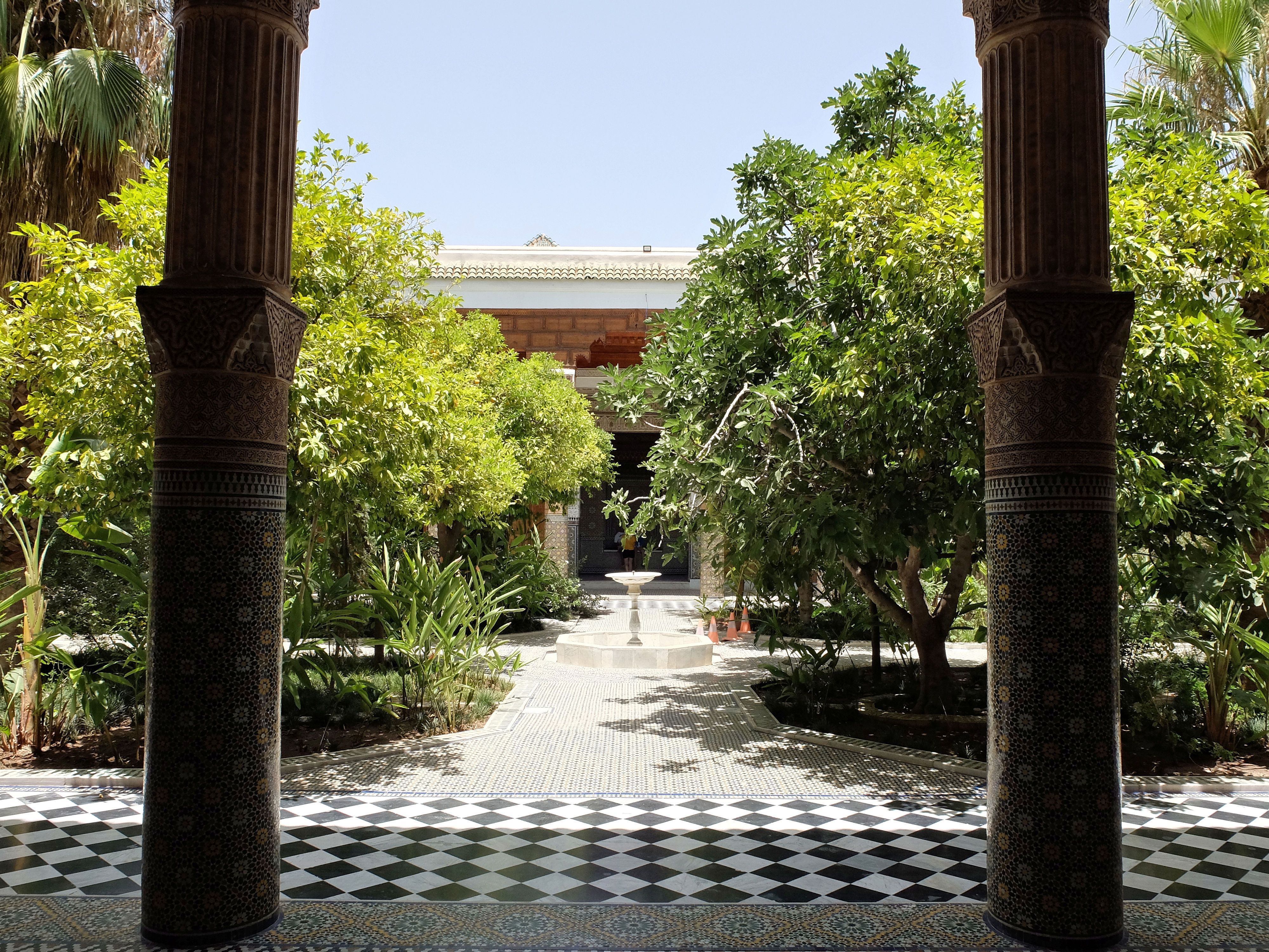 Inner garden planted with orange trees, seen between two columns, chequerboard zellige floor