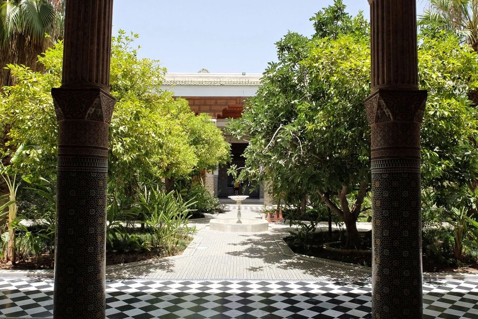 Inner garden planted with orange trees, seen between two columns, chequerboard zellige floor