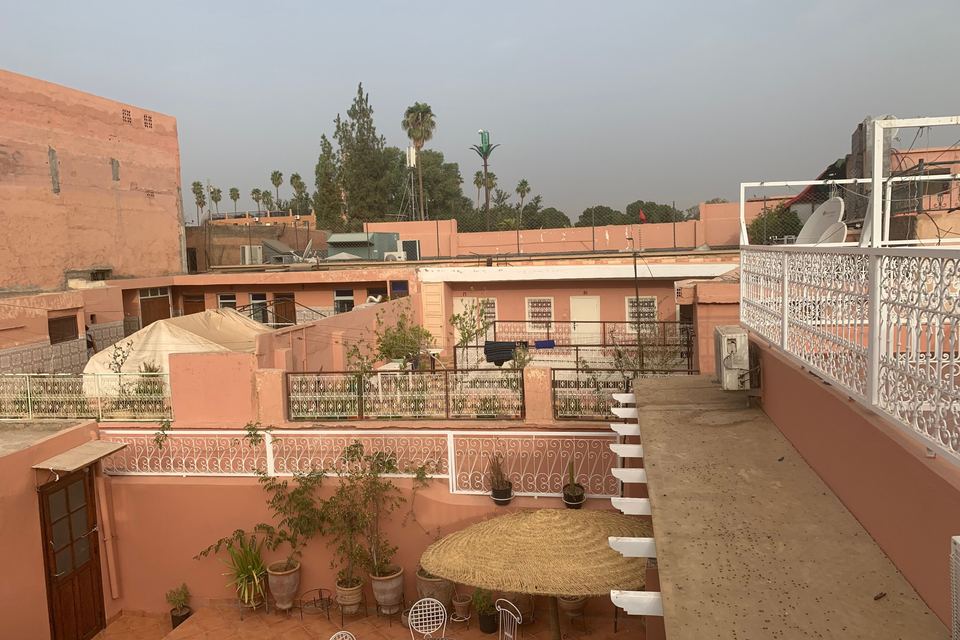 Rooftops of the Marrakech medina, a roof terrace with a table and wrought-iron railings