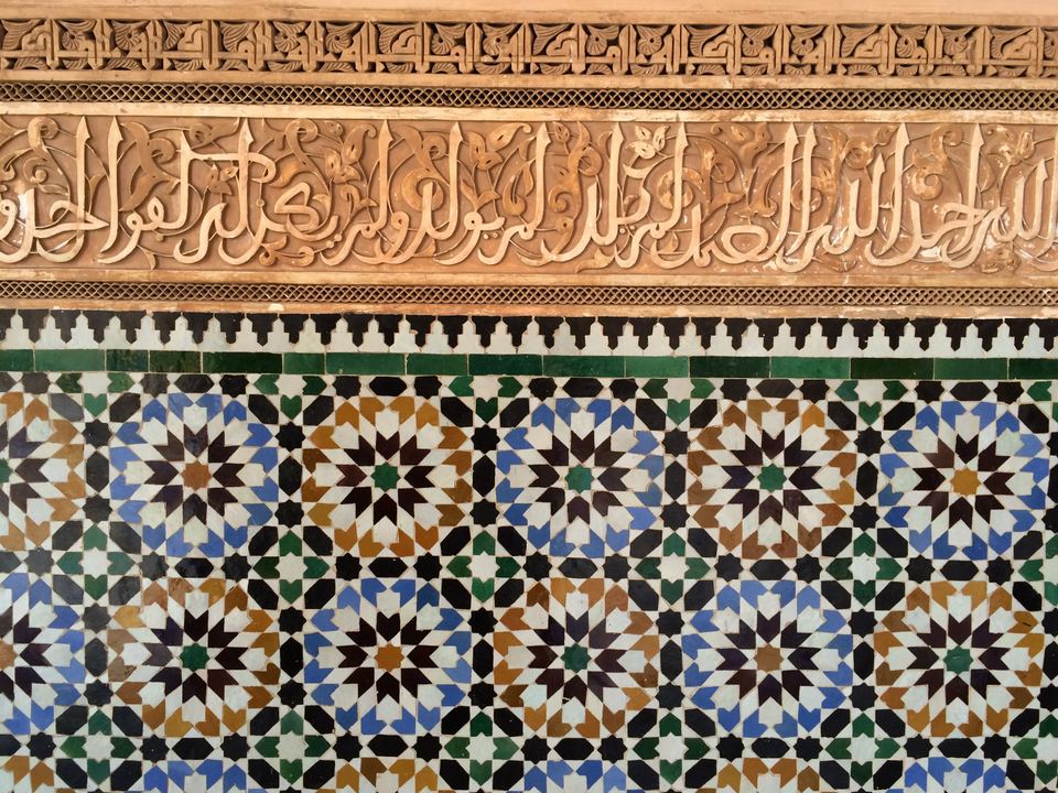 Detail of polychrome zellige beneath a carved stucco calligraphic frieze, Ben Youssef Madrasa