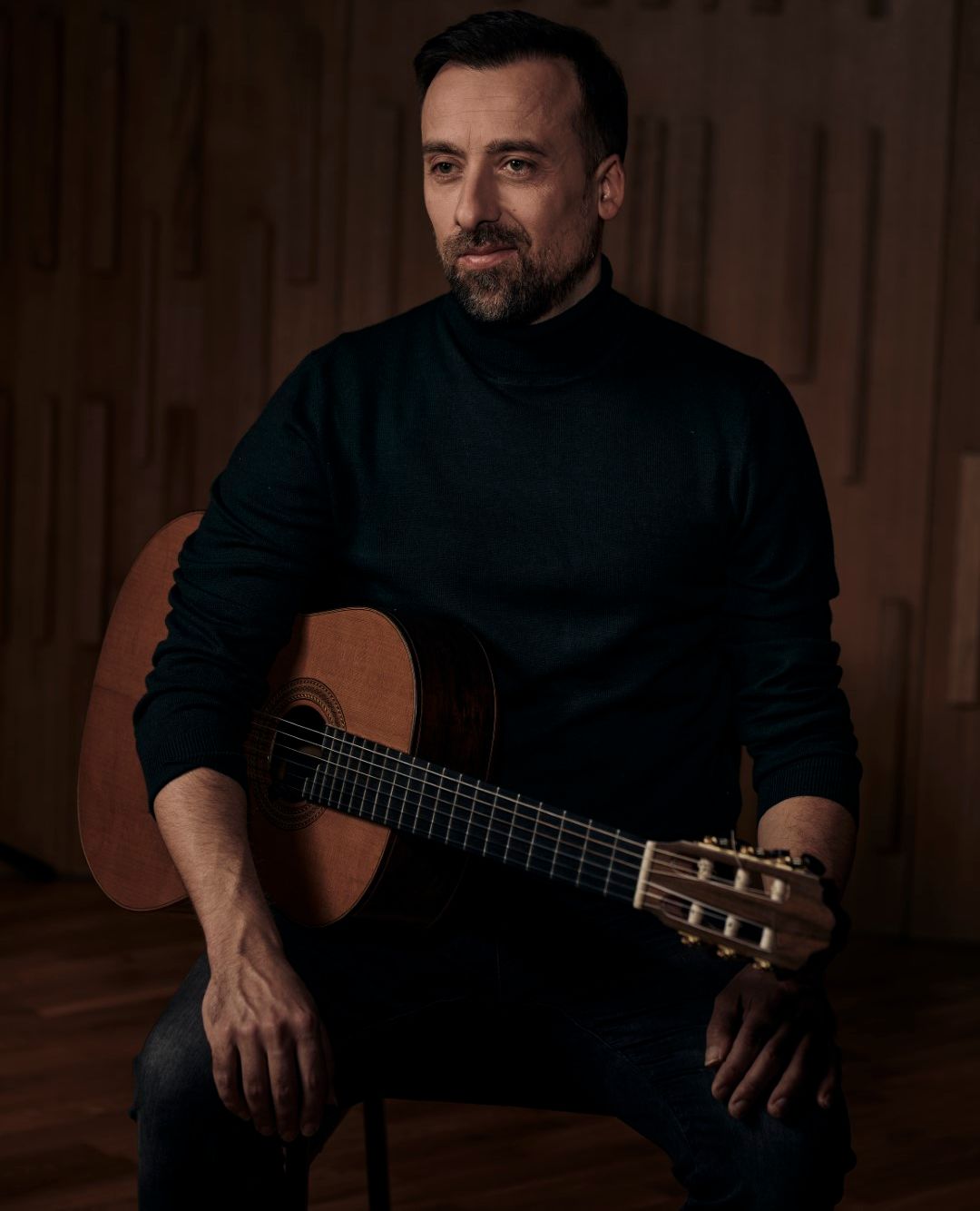 Danijel sitting with his guitar.