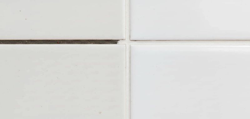 Confronto macro tra fuga porosa che assorbe macchie e fuga trattata con nanotecnologia che respinge i liquidi.