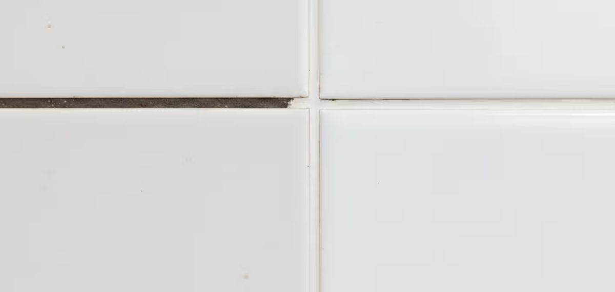 Confronto macro tra fuga porosa che assorbe macchie e fuga trattata con nanotecnologia che respinge i liquidi.